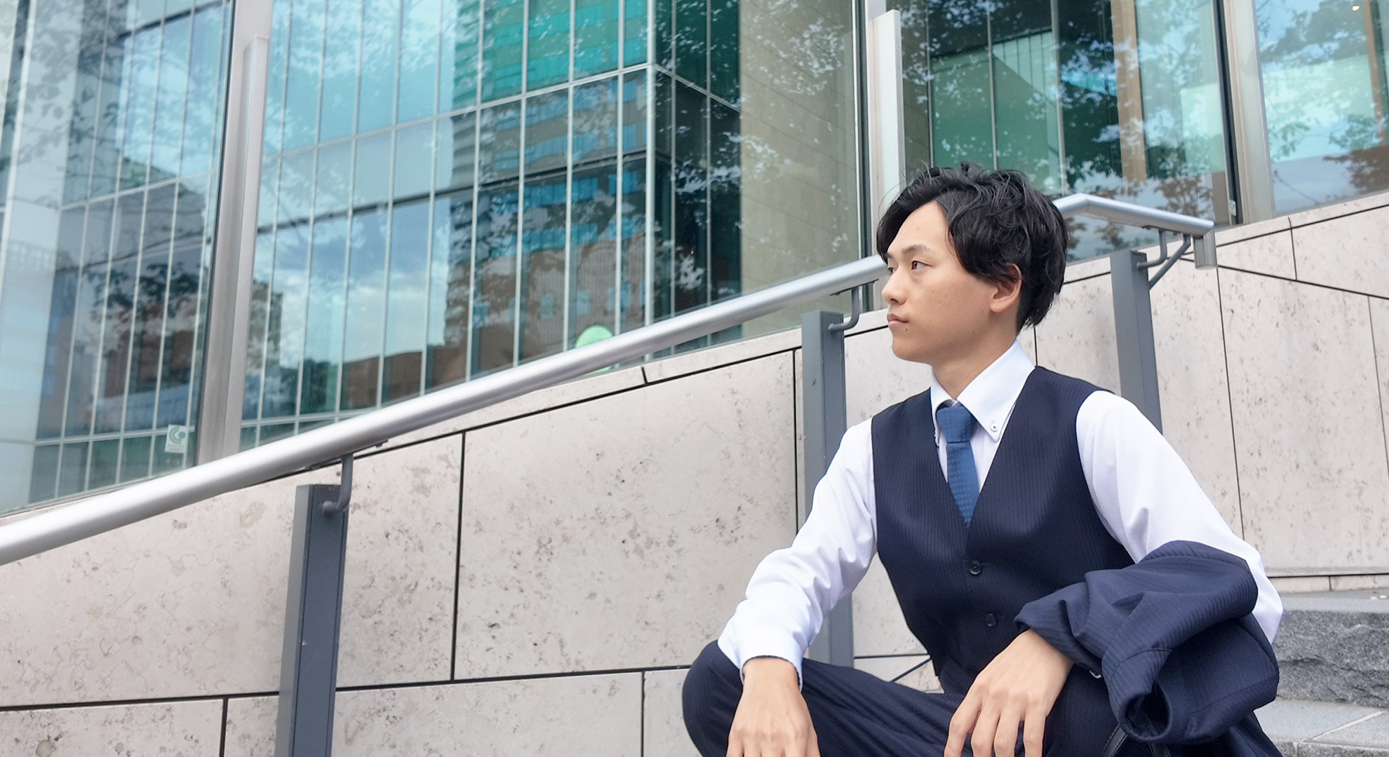 川沿いを歩く松本さんの後ろ姿