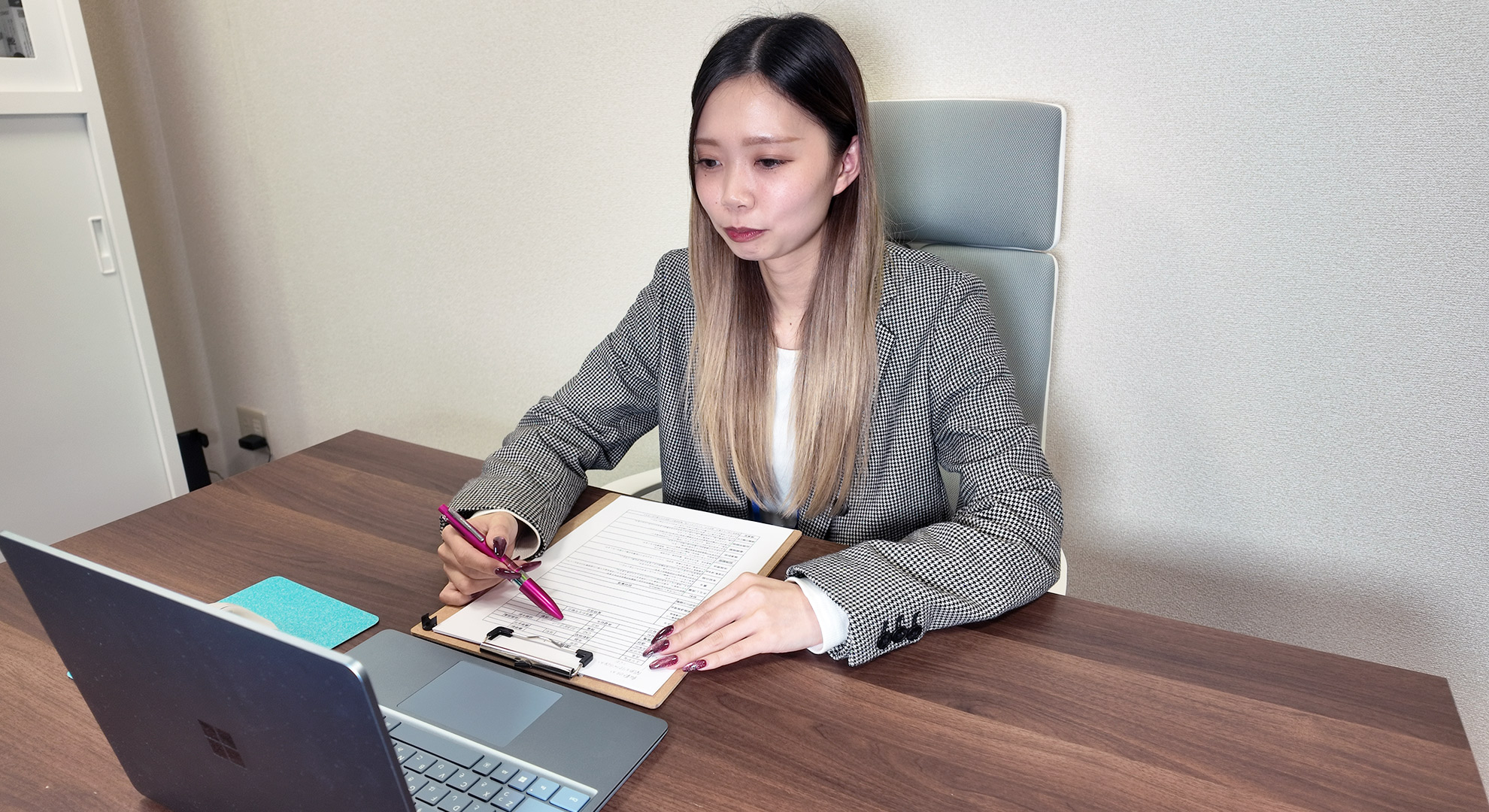 カンバンボードの前でマグネットを移動させる森田さん